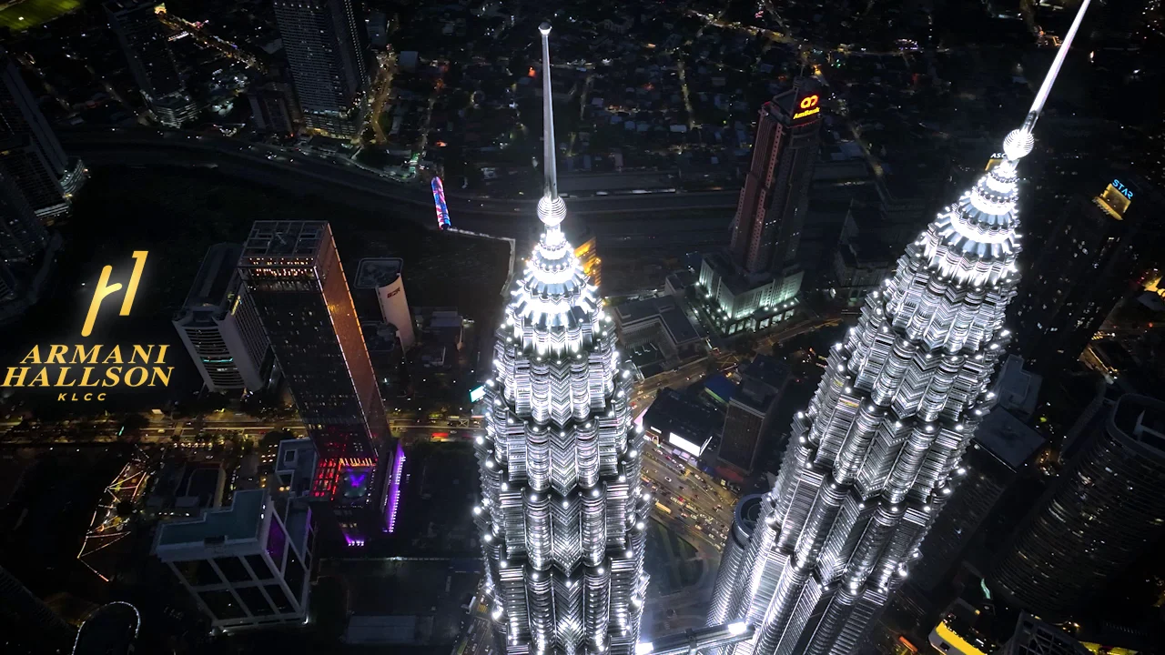 Armani Hallson KLCC — aerial drone view beside the Petronas Twin Towers spires at night